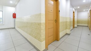A corridor with tiled walls and a wooden door. - Fabexpress Perfect (Samba)