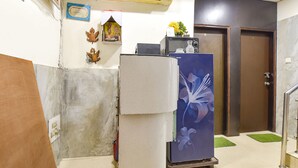 A compact kitchen with a refrigerator, microwave, and a small sink. - Fabexpress Glacier Inn (Jammu)