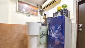 A reception area with a reception desk, a wall-mounted air conditioner, a framed picture, and a door. - Fabexpress Glacier Inn (Jammu)