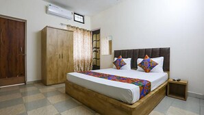 Un dormitorio con cama, armario de madera y aire acondicionado.