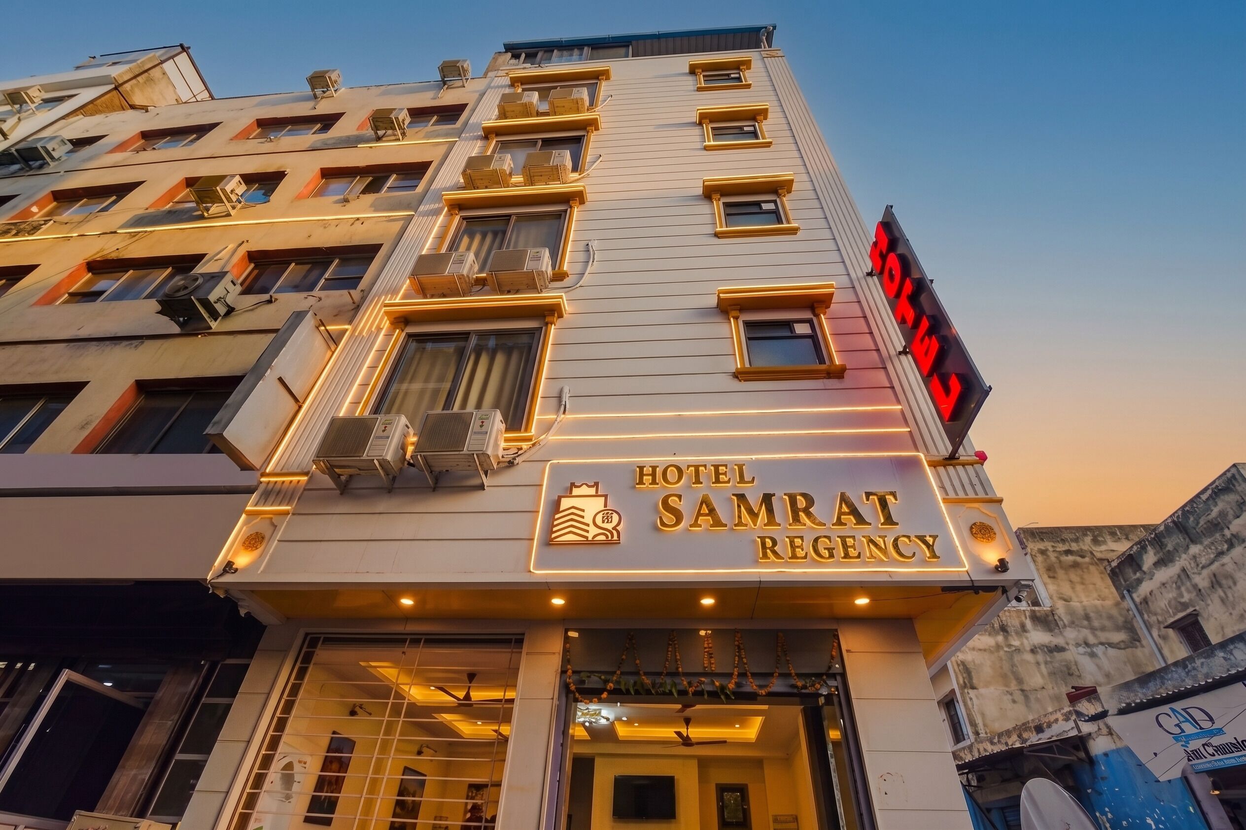 Een hotel met een bord waarop 'HOTEL SAMRAT REGENCY' staat.
