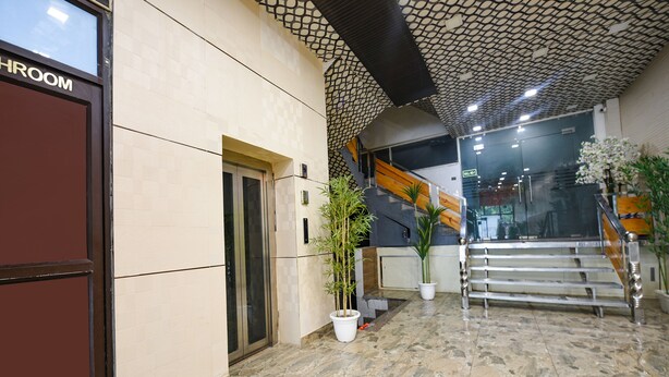 A modern interior with a tiled floor, a staircase, and potted plants. - Fabhotel The Crystal Palace (New Delhi)