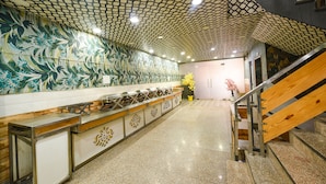 A modern kitchen with a patterned backsplash, a long counter, and a staircase with wooden steps. - Fabhotel The Crystal Palace (New Delhi)
