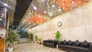 A lobby with a reception desk, a sofa, and potted plants. - Fabhotel The Crystal Palace (New Delhi)