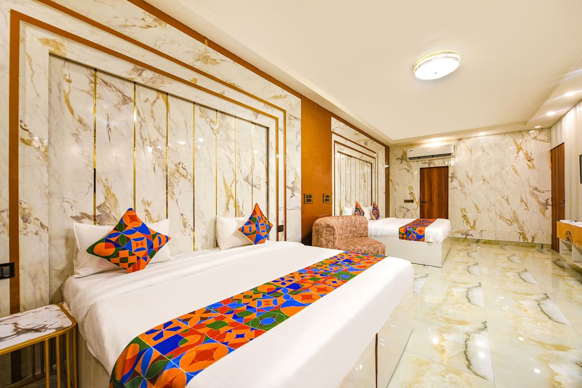 A hotel room with a large bed, a sofa, and a desk.