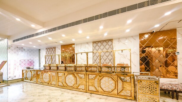 A reception area with a marble floor, a gold-colored reception desk, and decorative panels on the walls. - Fabhotel Royal'S Paradise (Faridabad)