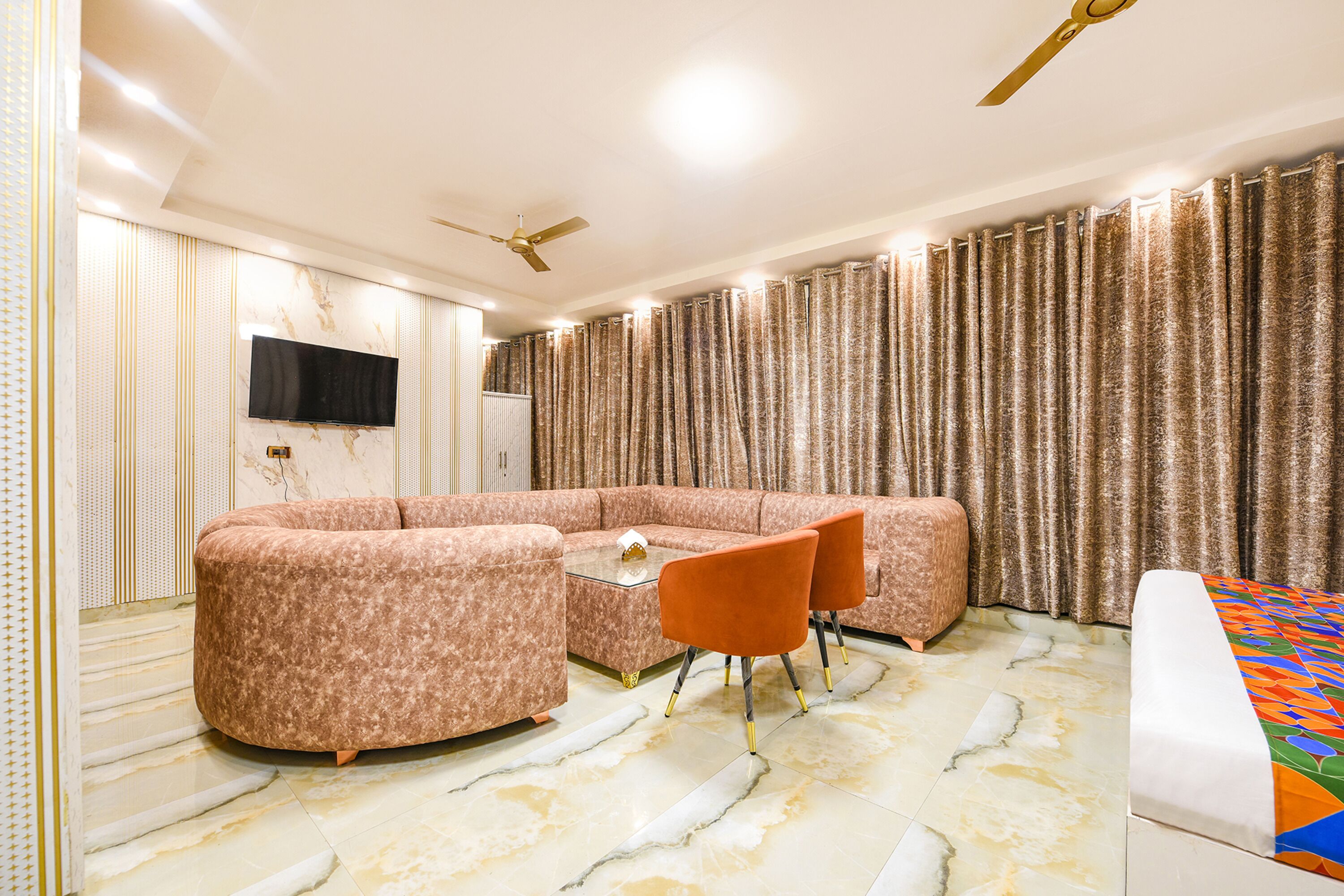 Ein modernes Wohnzimmer mit einem Ecksofa, einem Glastisch und zwei orangen Sesseln.