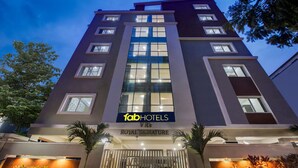 A multi-story hotel with a modern facade, large windows, and a sign for 'fabHOTELS VR's ROYAL SIGNATURE'.