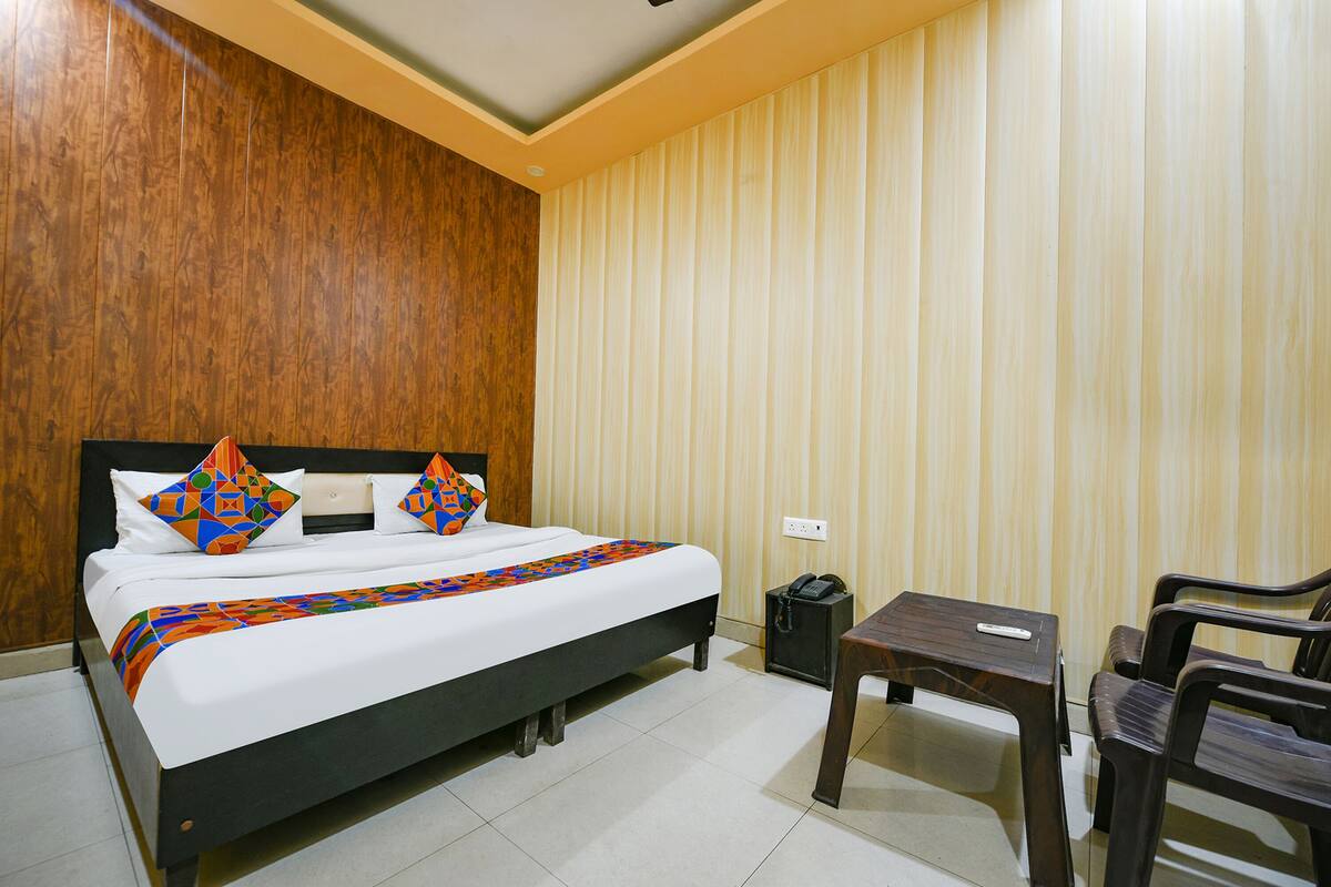 Ein Hotelzimmer mit einem Bett, einem kleinen Tisch und zwei Stühlen.
