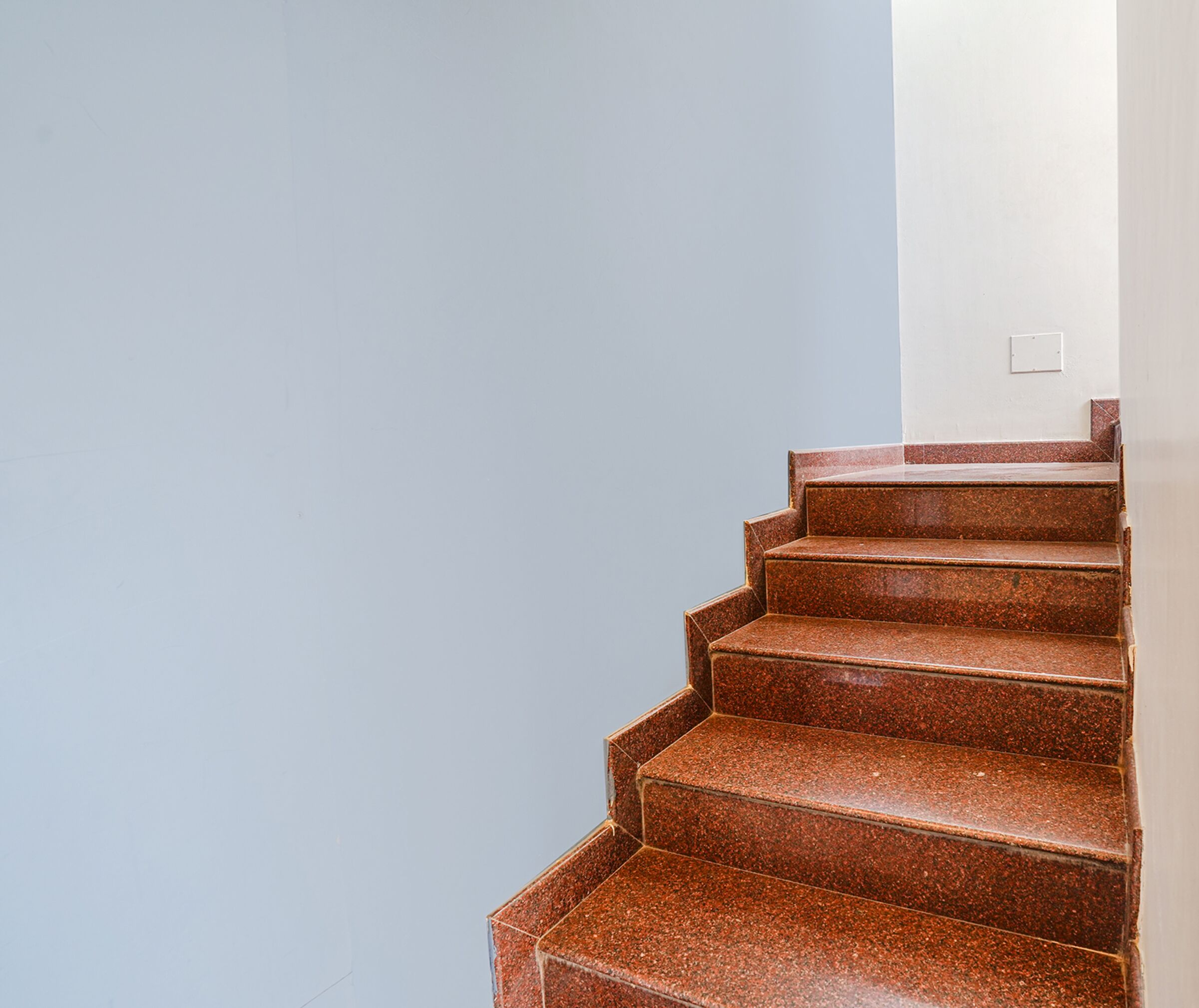 A set of red granite stairs leading up to a landing.