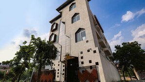 A modern building with a unique architectural design, featuring multiple windows and a prominent entrance. - Fabhotel Vasudha (Mathura)