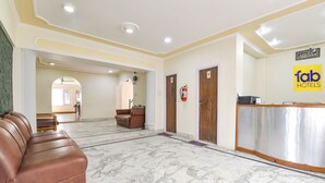 A hotel lobby with a reception desk, a brown leather sofa, and a marble floor. - Fabhotel Day'S Inn (Srinagar)