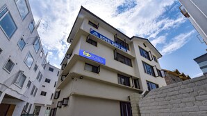 A multi-story hotel with a sign for 'Hotel Days Inn' and 'Tab Hotels'. - Fabhotel Day'S Inn (Srinagar)