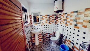 A bathroom with a tiled floor, a sink, a toilet, and a mirror. - Fabhotel Ta Hayaat (Srinagar)