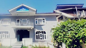 A two-story building with a balcony, a sign above the entrance, and a clear sky. - Fabhotel Ta Hayaat (Srinagar)
