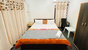 A hotel room with a bed, a desk, a chair, and a wardrobe. - Fabhotel Ta Hayaat (Srinagar)