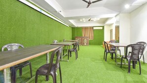 A conference room with green walls, multiple tables, and chairs. - Fabhotel Rajwada Palace (Jaipur)