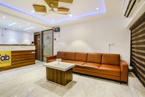 Welcome to Tab Hotels, where guests can relax on a comfortable sofa and enjoy a flat-screen TV.