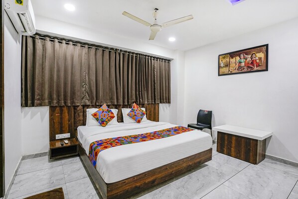 Cozy retreat with a large bed, bedside table, and ceiling fan.