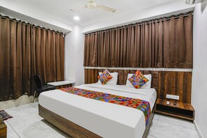 Relax in this inviting bedroom with a large bed, wooden headboard, and comfortable desk area.