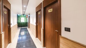 A hallway with wooden doors numbered 106, 109, and 110, leading to rooms. - Fabhotel Shaurya Inn (Lucknow)