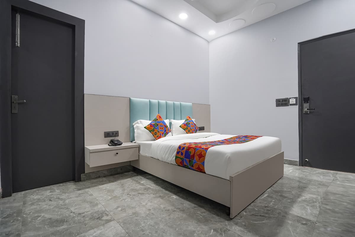 A modern bedroom with a bed, nightstands, and a door.