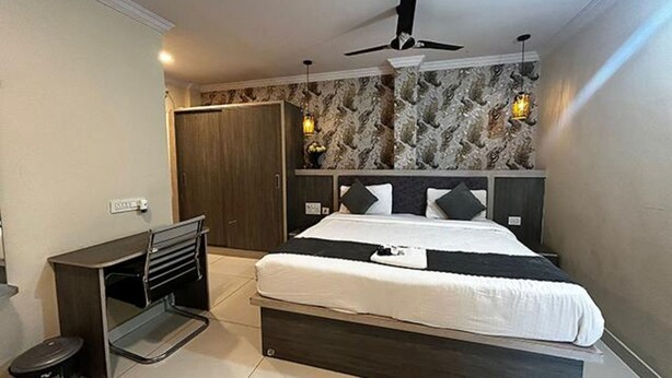 A bedroom with a bed, a desk, a wardrobe, and a ceiling fan. - Fabhotel Sprinkle Stay (Hyderabad)