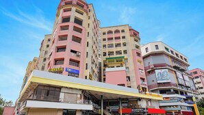 A multi-story building with various businesses including a hotel and a gym. - Fabhotel Crystal I (Gandhinagar)