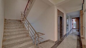 Un escalier avec une rampe métallique menant à un palier.