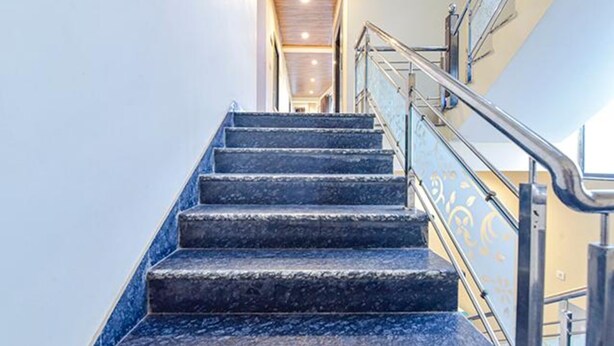 A staircase with metal railings and a handrail, leading to an upper floor. - Fabhotel Lali Palace (Udaipur)