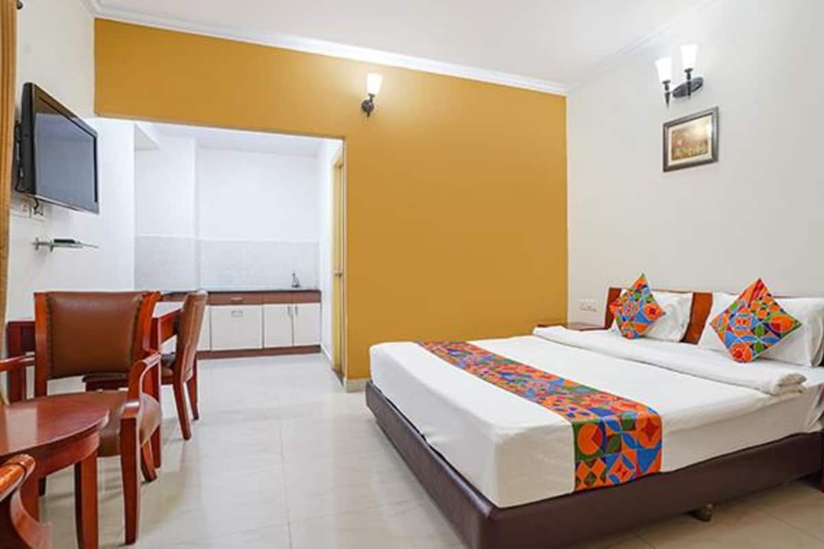 A hotel room with a bed, a desk, and a chair.