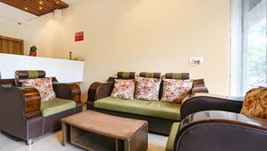 A modern living room with a sofa set, a coffee table, and a wooden ceiling. - Fabhotel Radhika Ex (Chhatrapati Sambhajinagar)
