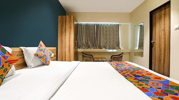 A hotel room with a bed, a desk, and a chair. - Fabhotel Radhika Ex (Chhatrapati Sambhajinagar)