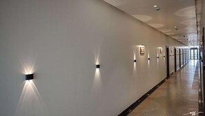 A long, well-lit corridor with recessed lighting and framed pictures on the walls. - Fabhotel Prime Lavkush (Raipur)