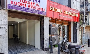 Un edificio con un letrero que anuncia habitaciones de lujo y una joyería llamada 'Rudra Jewellers'.