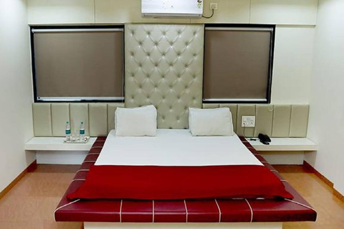 A hotel room with a large bed, two bedside tables, and a headboard with a tufted design.