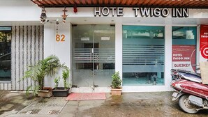 Entrada de un hotel con un letrero que dice "HOTEL TWIGO INN" y el número "82" sobre la puerta.