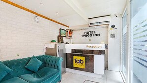 Una mesa de recepción con un letrero que dice 'Hotel Twigo Inn' y 'Tab Hotels'.