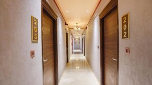 A hotel hallway with doors numbered 202 and 205, leading to rooms. - FabHotel Prime Tushar Elegant (Ghaziabad)