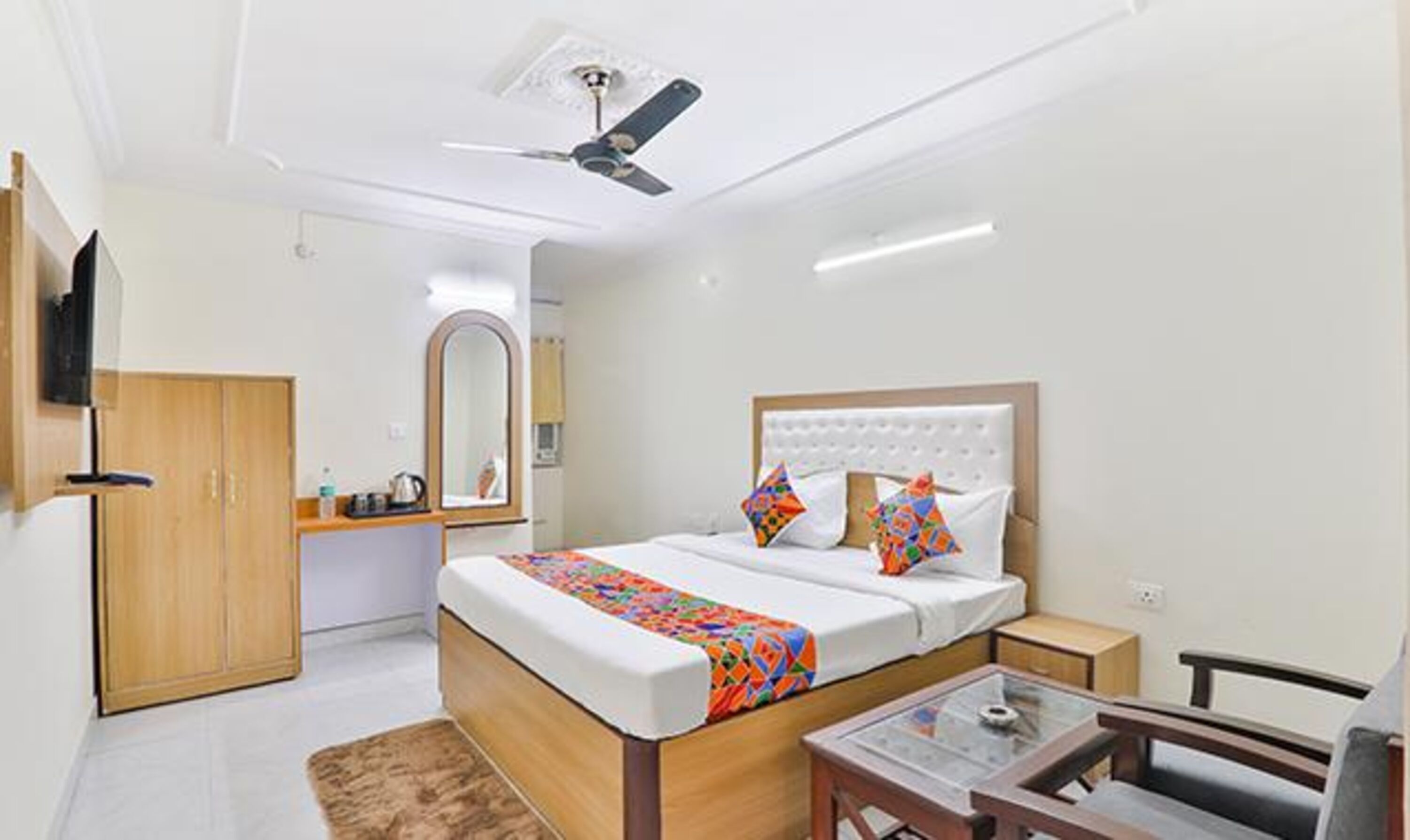 A modern bedroom with a bed, bedside table, and a ceiling fan.