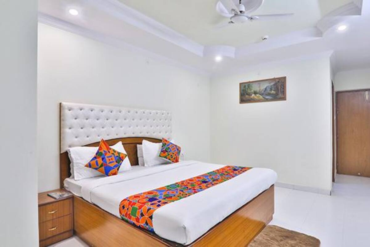 A bedroom with a bed, nightstand, and a ceiling fan.