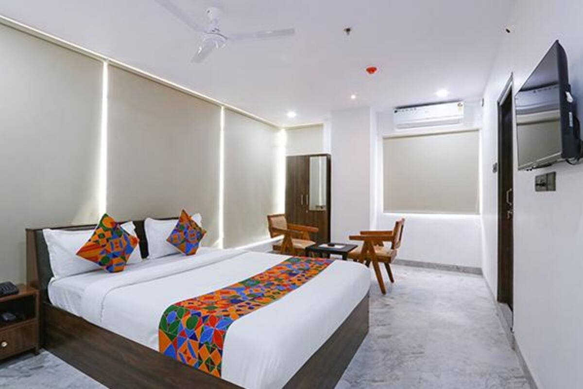 Une chambre d’hôtel moderne avec un grand lit, un bureau et une chaise.