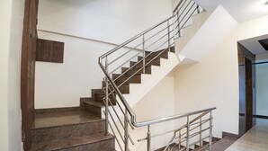 Una escalera con barandillas de metal y escalones de granito, que conduce a un piso superior.