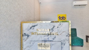 En receptionsdisk med skylten ”Shyam International” och en skylt med texten ”fab hotels” i bakgrunden.