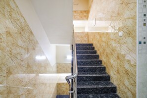 A marble staircase with a metal handrail, leading to an upper floor. - Fabhotel Sree Vishnu Bhavan (Tirupati)