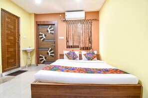 A bedroom with a wooden bed, a white bedside table, a wooden wardrobe, a ceiling fan, and a window with curtains.