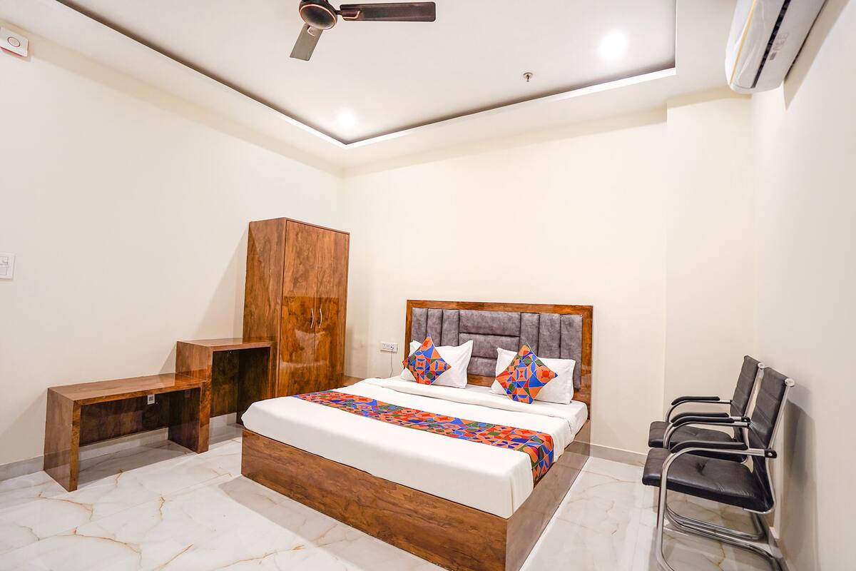 A bedroom with a bed, a bench, a wardrobe, and a ceiling fan.