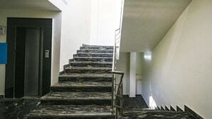 Una escalera con escalones de mármol negro que lleva a una plataforma.