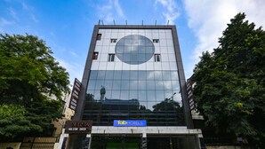 Un hotel moderno con una amplia fachada de vidrio que refleja el cielo.