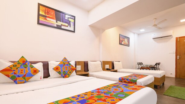 A hotel room with two beds, a desk, and a chair. - FabHotel Aksa Inn (Mumbai)